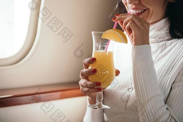 裁剪视图女人持有美味的鸡尾酒私人飞机