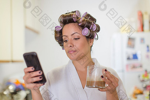 中期成人女人穿头发辊阅读文本消息智能手机