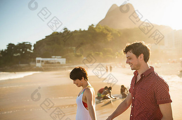 年轻的夫妇享受日落伊帕内玛海滩里约巴西
