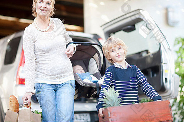 妈妈。婴儿车座位儿子携带盒子植物