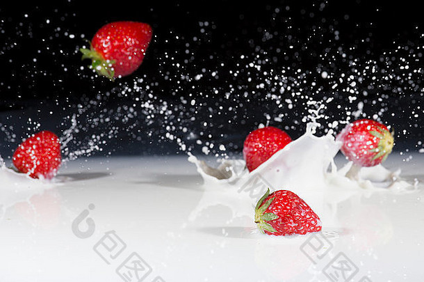 新鲜的草莓下降溅牛奶