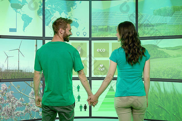 年轻的夫妇持有手站前面图形化的屏幕显示<strong>环境图片</strong>