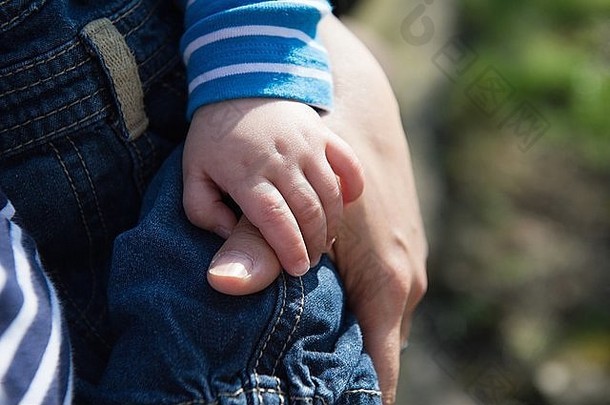 婴儿男孩持有母亲的拇指焦点手