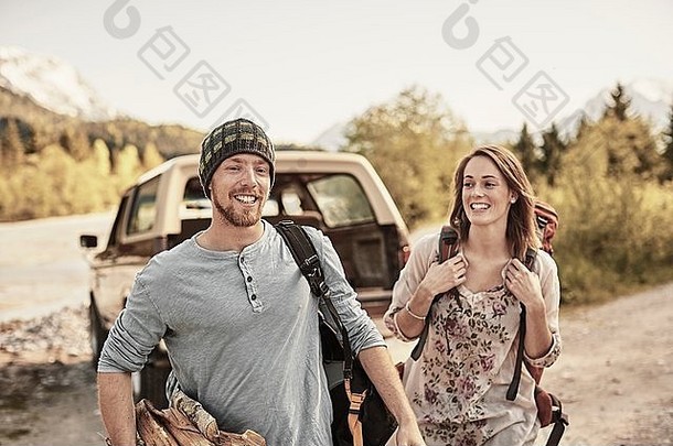 年轻的夫妇准备徒步旅行携带柴火微笑