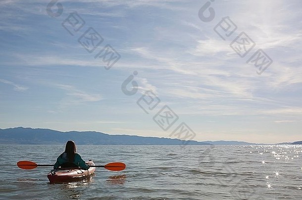 后视图年轻的女人皮划艇爱好者坐着皮艇水伟大的盐湖犹他州美国