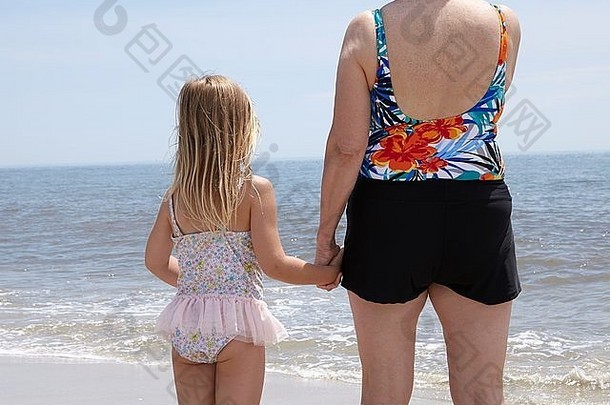 后视图高级女人（外）孙女持有手海滩