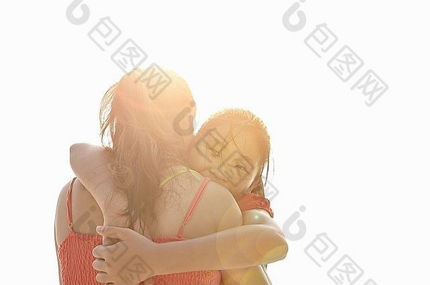 肩膀阳光照射的视图女孩拥抱妈妈。