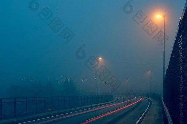 递减的角度来看光小径有雾的路照亮街灯HaugesundRogaland县挪威
