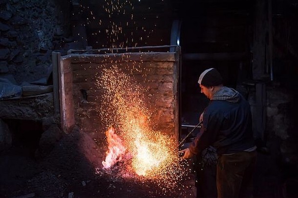 年轻的传统的铁匠工作开放火