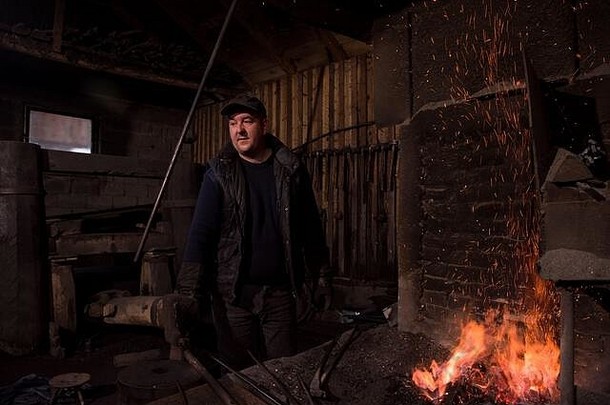 年轻的传统的铁匠工作开放火