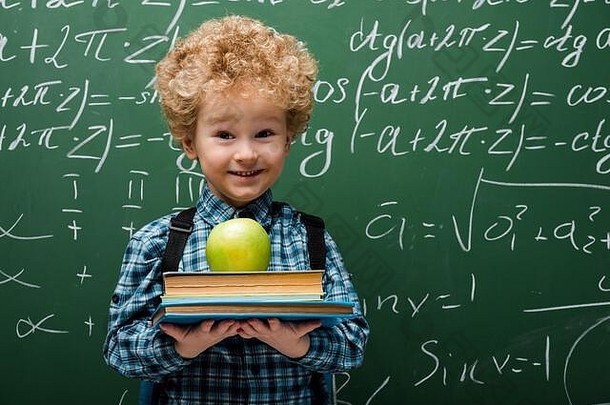 卷曲的孩子持有书苹果黑板数学公式