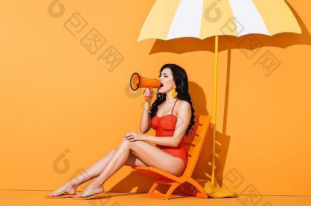 年轻的女人泳装持有扩音器尖叫坐着甲板椅子纸减少伞橙色