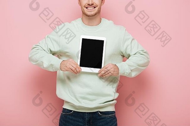 裁剪视图微笑男人。显示数字平板电脑空白屏幕粉红色的背景