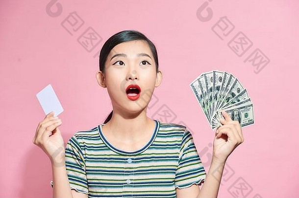年轻的亚洲夫人持有信贷卡风扇钱摆姿势孤立的粉红色的工作室背景女孩购物在线