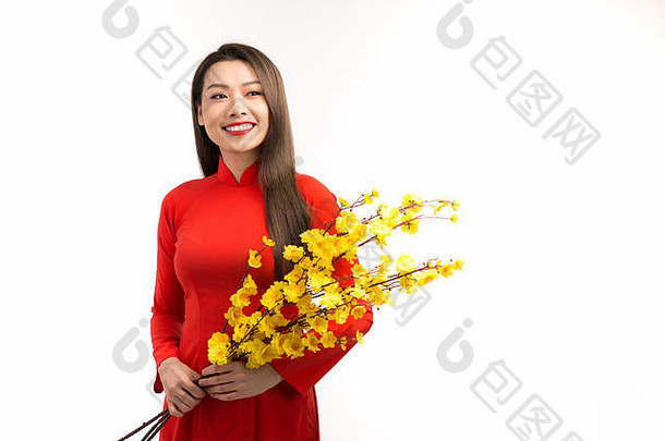 亚洲年轻的女孩穿传统的服装戴曼菊持有分支黄色的杏开花