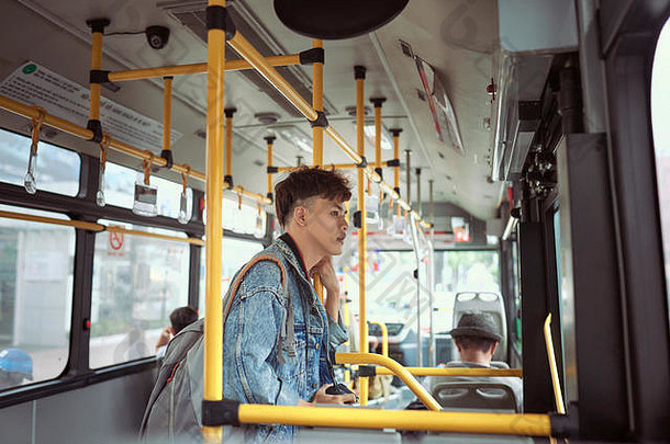 人生活方式旅行公共运输亚洲男人。站内部城市公共汽车