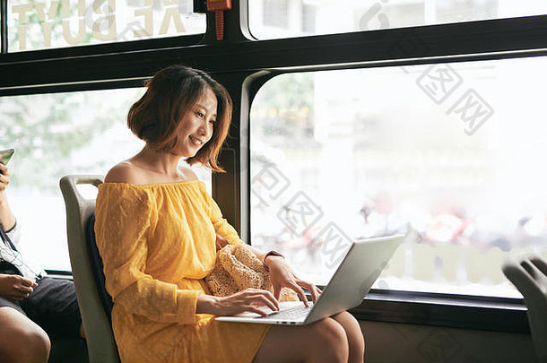 年轻的女商人业务旅行工作公共汽车移动PC