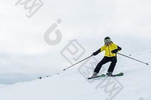 全景拍摄运动员持有滑雪棒滑雪白色雪