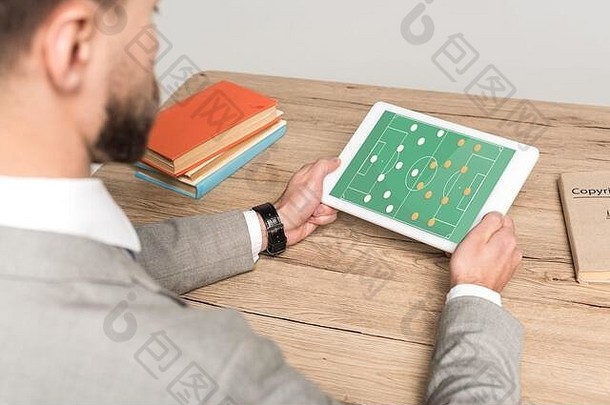 裁剪视图商人玩足球视频游戏移动PC孤立的灰色