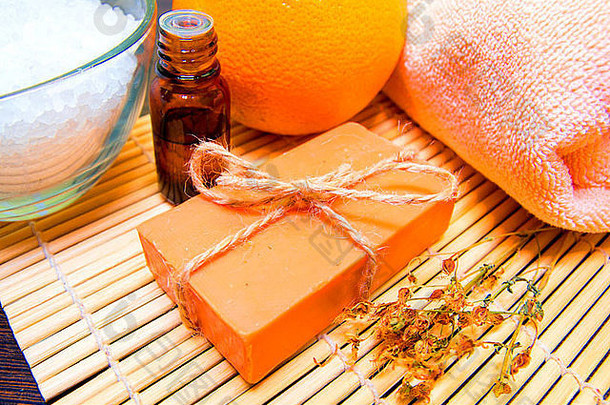 自然手工制作的肥皂至关重要的石油干草本植物浴盐橙色毛巾竹子席水疗中心概念