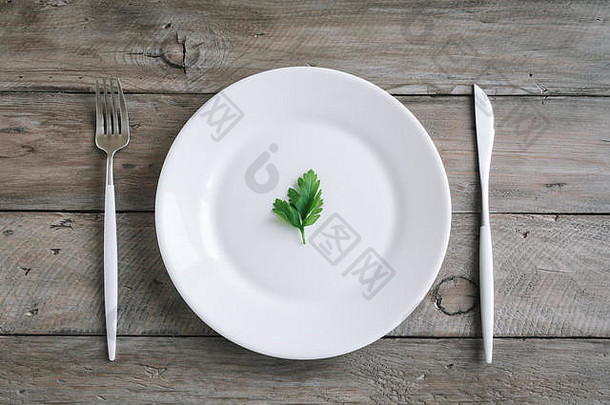 表格设置白色板现代餐具叉刀叶新鲜的欧芹木背景前视图复制空间饮食方式