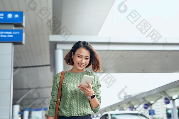 亚洲女人检查智能手机等待机场亚洲