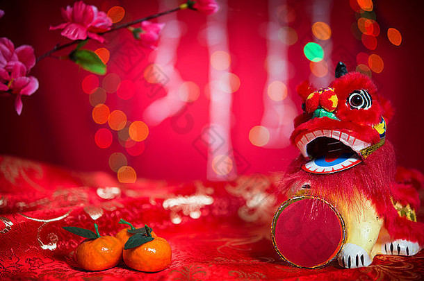 中国人一年节日装饰微型跳舞狮子普通话橙色红色的闪闪发光的背景