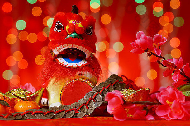 中国人一年装饰微型跳舞狮子古老的钱红色的闪闪发光的背景