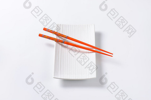 一对橙色筷子白色板