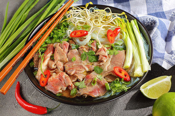 越南汤巨像大米面条生牛里脊肉牛肉片豆豆芽石灰春天洋葱黑色的碗筷子成分