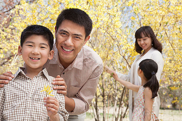 快乐微笑父母孩子们享受公园春天花