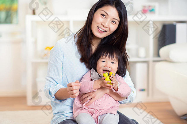 漂亮的快乐日本妈妈。玩可爱的蹒跚学步的女儿首页