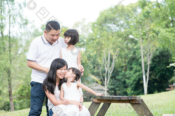 亚洲家庭肖像父母孩子们有趣的户外公园空空间木表格