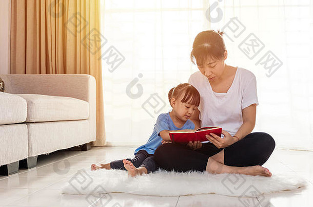 亚洲中国人妈妈。女儿阅读地板上首页