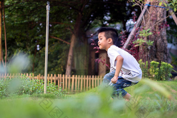 中国人孩子男孩屈膝；蜷伏公园