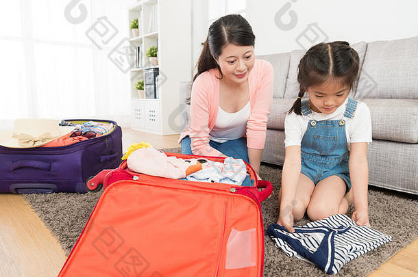 漂亮的女人教学年轻的女孩折叠个人服装生活房间包装行李手提箱准备旅行