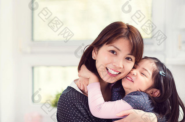 肖像快乐日本妈妈。拥抱可爱的女儿首页