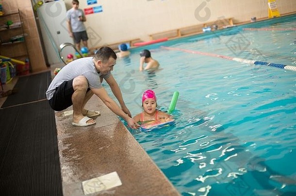 漂亮的女孩学习游泳池游泳教练教练