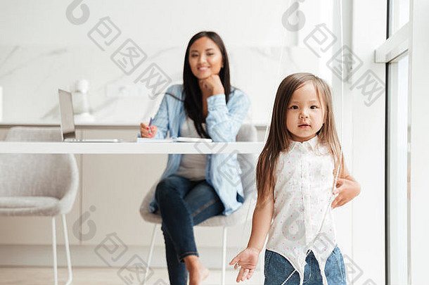 可爱的亚洲女孩玩妈妈。工作移动PC首页