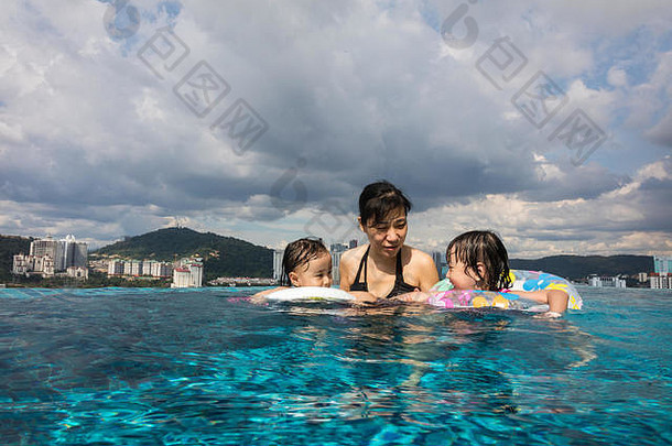 亚洲中国人家庭玩户外游泳池假期夏季