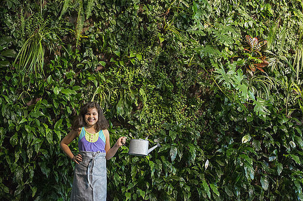 年轻的女孩站前面墙覆盖蕨类植物攀爬植物
