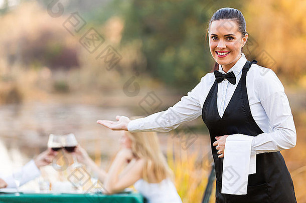 漂亮的年轻的女服务员欢迎客户浪漫的餐厅环境