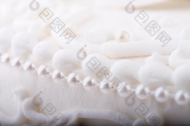白色婚礼蛋糕细节特写镜头根据漩涡装饰珍珠