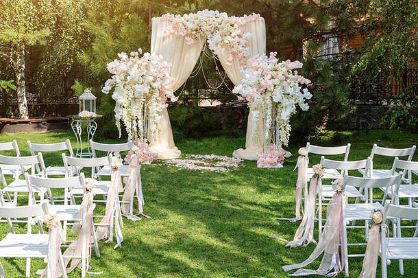 婚礼拱装饰布花在户外美丽的婚礼集婚礼仪式绿色草坪上花园部分节日装饰花安排
