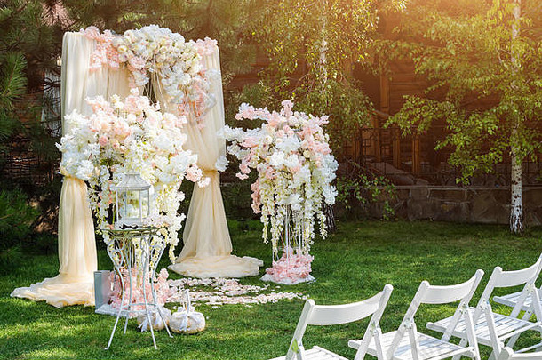 婚礼拱装饰布花在户外美丽的婚礼集婚礼仪式绿色草坪上花园部分节日装饰花安排