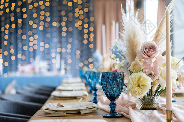 婚礼宴会联欢晚会晚餐椅子表格客人服务餐具陶器覆盖柔和的粉红色的桌布跑步者聚会，派对点燃花环