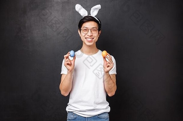 假期聚会，派对复活节概念肖像快乐微笑友好的亚洲的家伙兔子耳朵庆祝正统的神圣的一天持有画鸡蛋