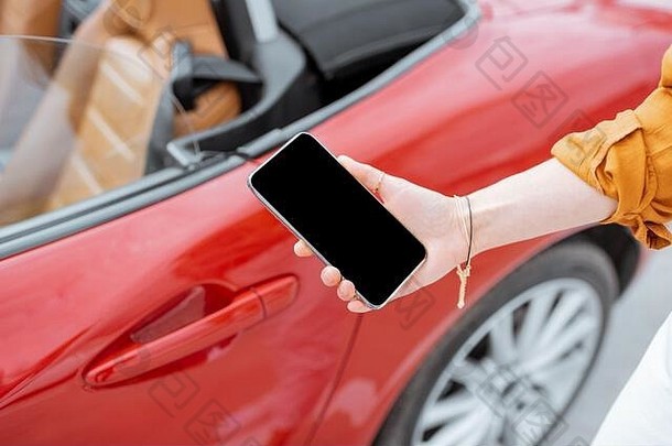 女人持有智能手机车通过特写镜头视图电话黑色的屏幕复制粘贴车远程控制概念