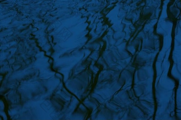 摘要模糊树镜像反射波及水表面黑暗蓝色的颜色爽肤水