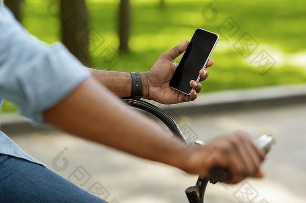 非洲式发型男人。骑自行车智能<strong>手机</strong>黑色的屏幕